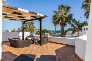 een terras met uitzicht op de oceaan en palmbomen bij Villa Eva by OCvillas in Sesmarias