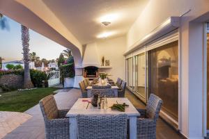 a patio with tables and chairs and a fireplace at Villa Eva by OCvillas in Albufeira