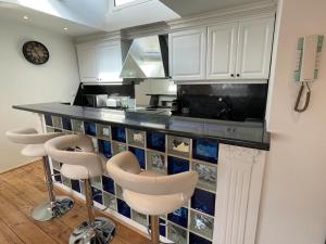 a kitchen with white cabinets and a counter with stools at Le Croisette center in Cannes