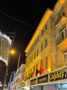 a building with a lot of flags on it at night at Gaziantep Taşhan Hotel in Gaziantep