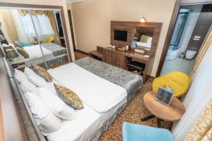 イスタンブールにあるMa City Hotelの大きなベッドとデスクが備わるホテルルームです。