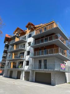 a tall white apartment building with balconies on it at Apartament Michaś in Szklarska Poręba