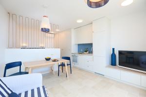 eine Küche und ein Wohnzimmer mit einem Tisch und einem TV in der Unterkunft Hedera Estate Hedera Studio 1 in Dubrovnik