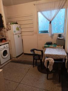 eine Küche mit einem Tisch, einem Kühlschrank und einem Fenster in der Unterkunft Ain sbaa Hay mohmmadi in Casablanca