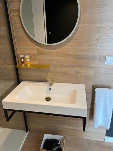 a white sink in a bathroom with a mirror at COCON NOELY 1 in Toulouse