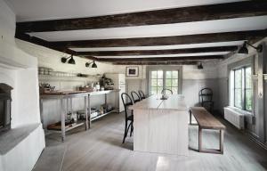 una cucina con tavolo e sedie in una stanza di Kungs Starby Gård Bed and Breakfast a Vadstena