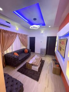 a living room with a couch and a blue ceiling at GOD'S TOUCH APARTMENTS SHORT-LET Adenugba Street Oregun Ikeja Lagos Nigeria in Ikeja