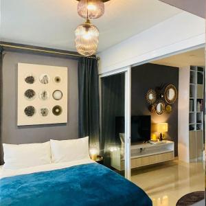 sypialnia z niebieskim łóżkiem i lustrem w obiekcie Seaview Bliss Studio By Tropical Elegance w mieście Kota Kinabalu