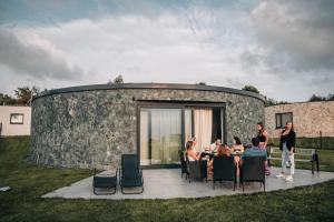 a group of people sitting at a table in front of a stone building at Villa Kořenec in Kořenec