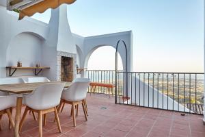 a dining room with a table and chairs on a balcony at Casa Sierra - Mijas Pueblo in Mijas
