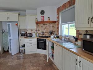 a kitchen with white cabinets and a stove top oven at The Viewpoint in Newry