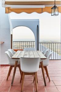 una mesa y sillas en un balcón con vistas al océano en Casa Sierra - Mijas Pueblo, en Mijas