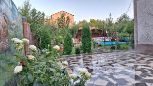 a courtyard with a garden with white roses at Garni family house B&B in Garni