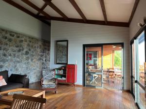ein Wohnzimmer mit einem Sofa und einem Tisch in der Unterkunft Villa atypique le chat perché de Grand Anse in Petite Île
