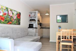 a living room with a couch and a kitchen at Sandwig-Lodge in Glücksburg