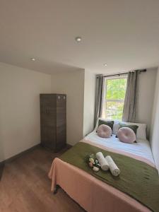 een slaapkamer met een bed met kussens en een raam bij 3 Bedroom Flat in King’s Cross, St Pancras’s. 2 minutes to Euston. in Londen