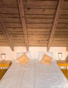 a bed in a room with wooden ceilings at ZielonoMi in Zieleniak