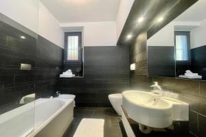 梅納焦的住宿－Menaggio 57，黑白浴室设有水槽和浴缸。