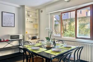 梅納焦的住宿－Menaggio 57，一间带桌椅和窗户的用餐室