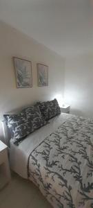 een slaapkamer met een bed met een zwart-witte deken bij Ballarhouse an elegant apartment in Palermo