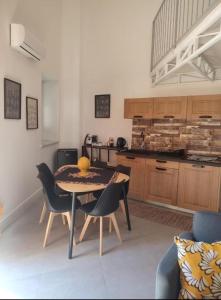 een keuken met een tafel en stoelen in een kamer bij Ballarhouse an elegant apartment in Palermo