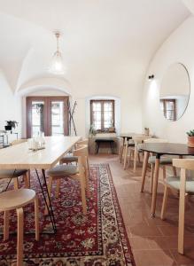 une salle à manger avec des tables, des chaises et un tapis dans l'établissement Masná 130, à Český Krumlov