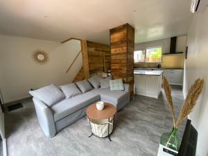 een woonkamer met een bank en een tafel bij Duplex le Corten, Terrasse et jardin in Gérardmer