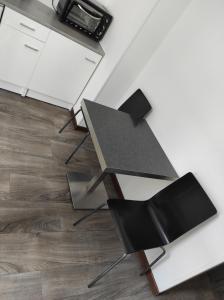 una mesa y 2 sillas en una cocina en Appart Cosy Henin Centre, en Hénin-Beaumont