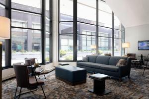 sala de estar con sofá, sillas y ventanas en Des Moines Marriott Downtown en Des Moines