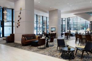 a lobby with chairs and tables and windows at Des Moines Marriott Downtown in Des Moines
