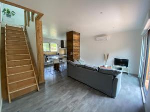 ein Wohnzimmer mit einer Couch und einer Treppe in der Unterkunft Duplex le Corten, Terrasse et jardin in Gérardmer