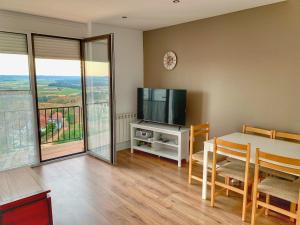 a living room with a table and a tv and a dining table and a television at El Carmen in Toro