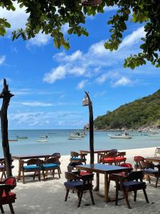 a group of tables and chairs on a beach at Havana Beach Resort Phangan in Thong Nai Pan Yai