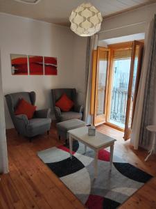 a living room with two chairs and a coffee table at Can Penjarella I in Arbúcies