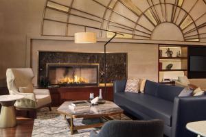 a living room with a blue couch and a fireplace at Sheraton Istanbul Levent in Istanbul