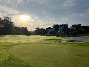 a lush green golf course with the sun setting on at ED Studio 34@DPAC/IKEA/1 Utama/TTDI in Petaling Jaya