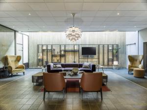 eine Lobby mit einem Sofa und Stühlen sowie einem TV in der Unterkunft Radisson Blu Hotel Bodø in Bodø