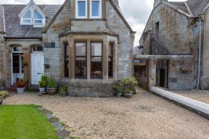 une ancienne maison en pierre avec une cour dans l'établissement St Meddans Mews - Donnini Apartments, à Troon