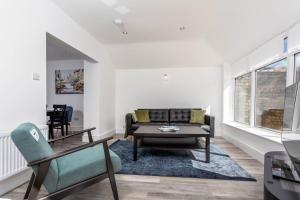 a living room with a couch and a table at St Meddans Mews - Donnini Apartments in Troon