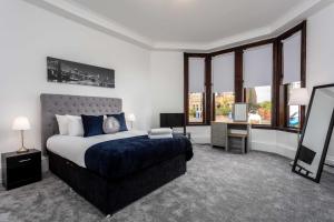 a bedroom with a bed and a television in it at St Meddans Mews - Donnini Apartments in Troon