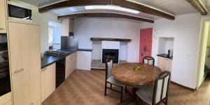 a kitchen and dining room with a table and a fireplace at Sirogn House in Gordola