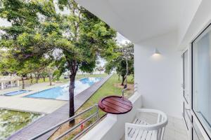 een balkon met uitzicht op een zwembad bij Trinco Blu by Cinnamon in Trincomalee