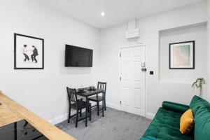 uma sala de estar com um sofá verde e uma mesa em Cosy Modern Apartment With Free Parking em Cardiff