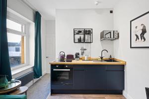 a black and white kitchen with a sink and a window at Cosy Modern Apartment With Free Parking in Cardiff