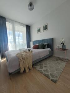 a bedroom with a bed with a blanket on it at Komfortowy apartament z balkonem i parkingiem in Wrocław