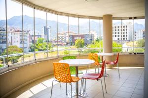 a balcony with tables and chairs and a view of a city at Sirin Residence in Denizli