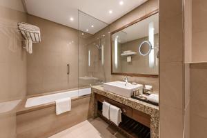 bagno con lavandino, vasca e specchio di Renaissance Cairo Mirage City Hotel a Il Cairo