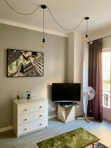 a living room with a television and a white dresser at Studio centre ville in Nîmes