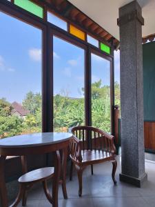 uma mesa e cadeiras num quarto com uma janela em Dalem Arum (for women only) em Bandung