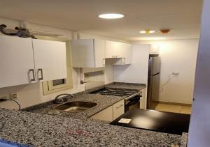 eine Küche mit weißen Schränken und einer Spüle in der Unterkunft Spacious 2Bdrs duplex in Porto new Cairo in Kairo